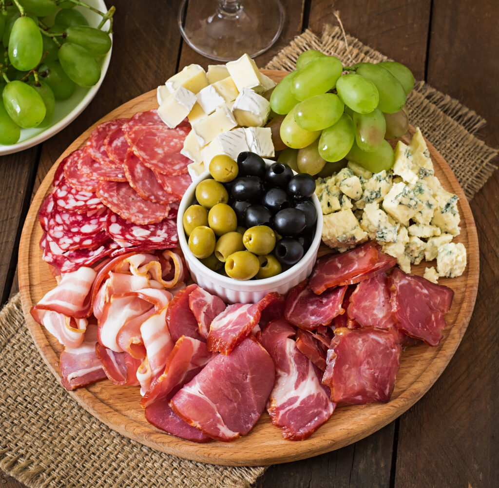 plateau-restauration-antipasto-bacon-saccade-salami-fromage-raisins-table-bois
